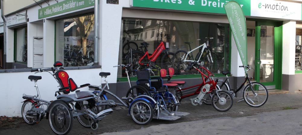Eine Auswahl an verschiedenen Dreirädern vor dem Dreirad-Zentrum in Köln