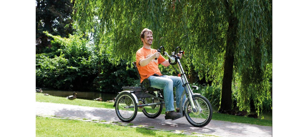 glücklicher Mann auf einem Dreirad im Park